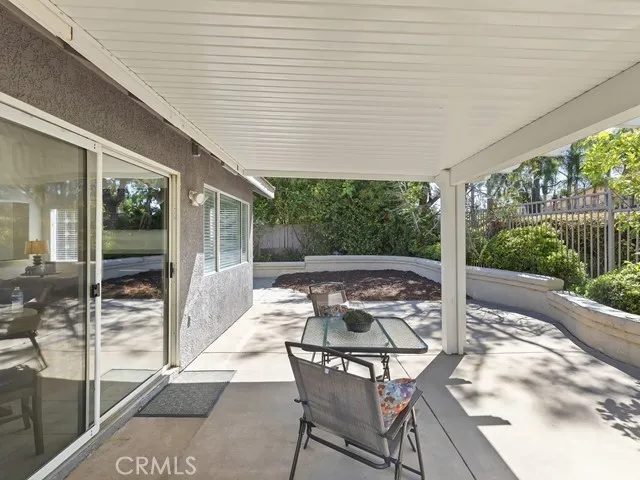 a patio with yard glass top table and chairs