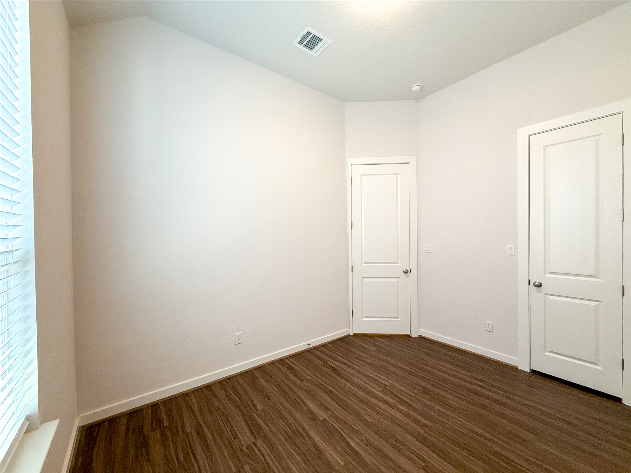 249 Heartleaf Road San Marcos, TX 78666 - Photo 25 of 38 Rich hardwood-style flooring extends across this versatile room, offering ample space for personalized use.