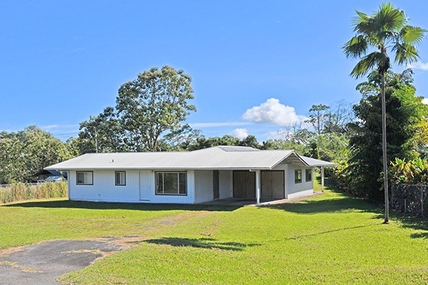 17-239 Volcano Road Keaau, HI 96749 - Photo 1 of 25 a front view of a house with a yard and garage