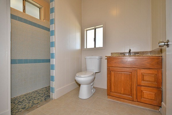 17-239 Volcano Road Keaau, HI 96749 - Photo 19 of 25 a bathroom with a granite countertop toilet a sink and a mirror