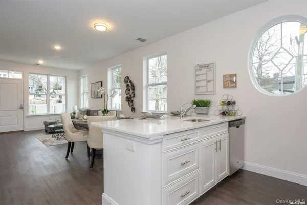 a kitchen with sink and view of living room