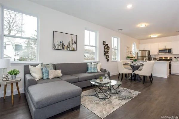 a living room with furniture dining table and a large window