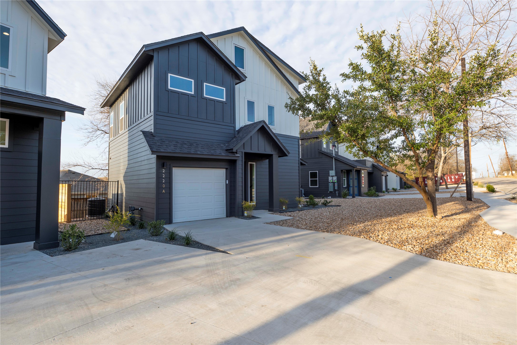 2220 Yellow Jacket Lane, Unit 1 Austin, TX 78741 - Photo 4 of 35 Modern townhomes feature bold, contrasting siding and individual garage access.