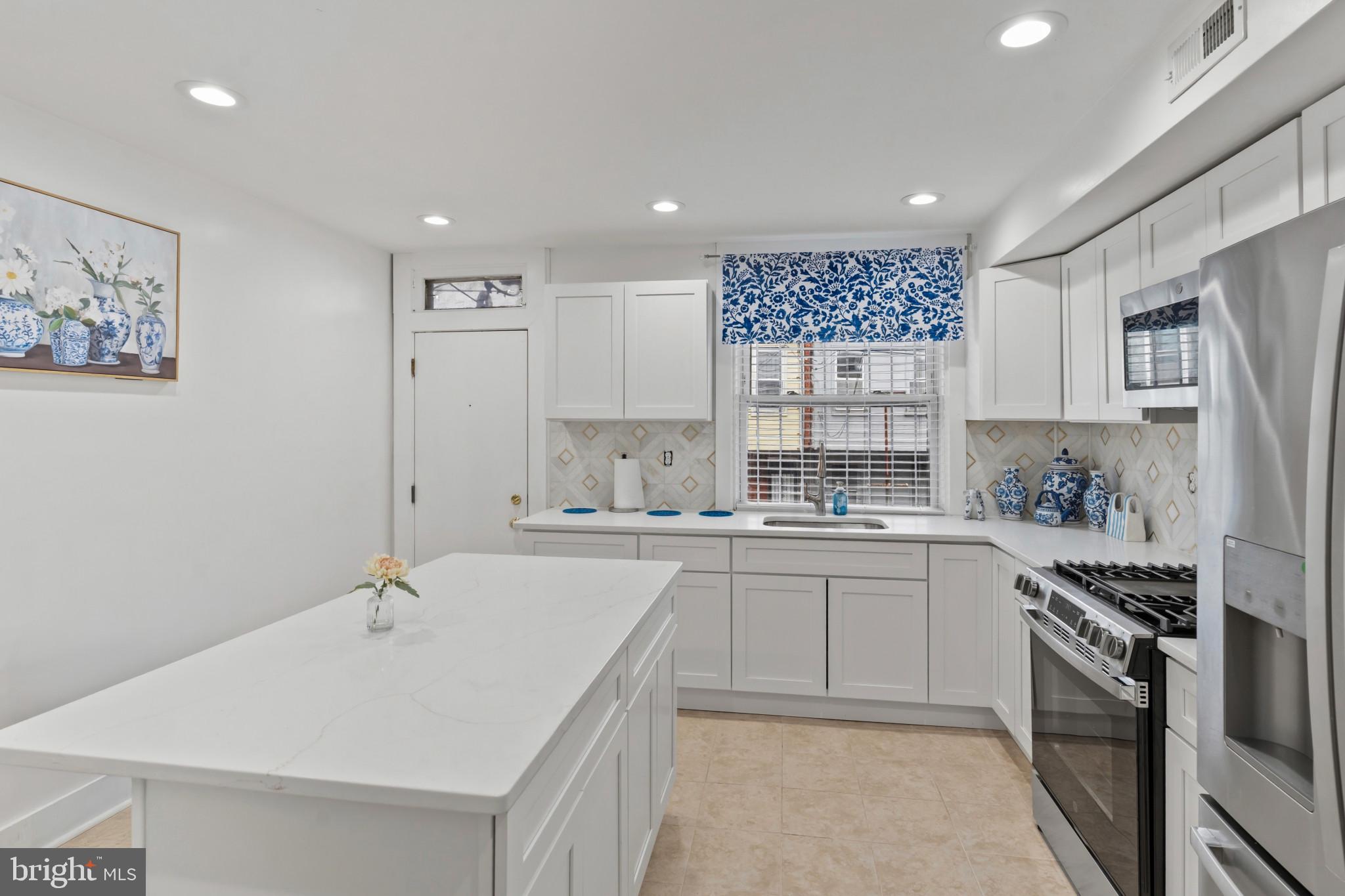 2609 East Hoffman Street Baltimore, MD 21213 - Photo 6 of 22 a kitchen with stainless steel appliances granite countertop a sink stove and refrigerator