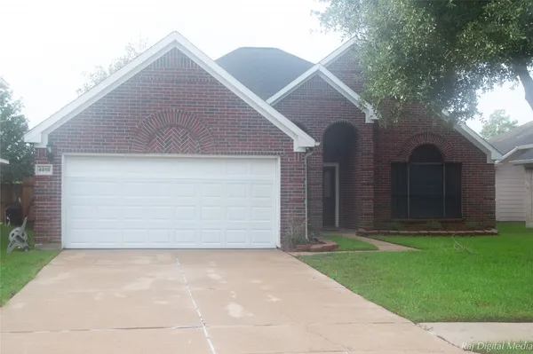 a front view of a house with a garden and yard