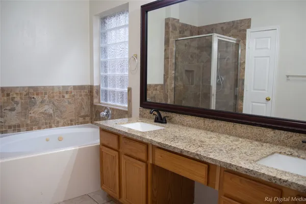 a bathroom with a granite countertop sink and a bathtub