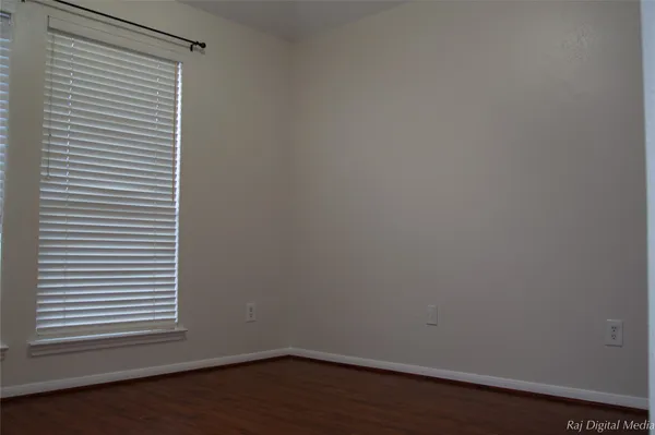 a view of a small space with wooden floor and a window