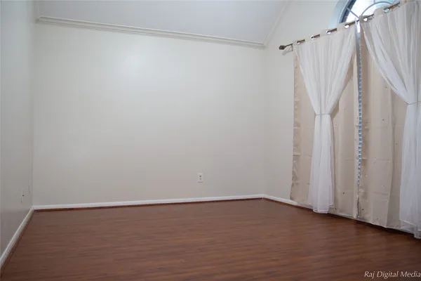 a view of a room with wooden floor and white walls
