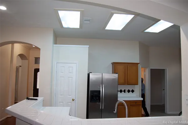 a kitchen with stainless steel appliances kitchen island granite countertop a refrigerator a stove and a refrigerator