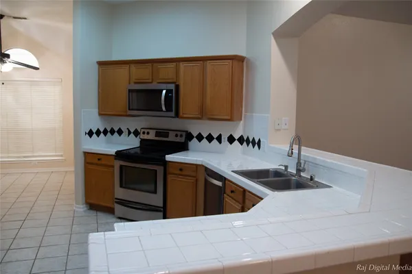 a kitchen with stainless steel appliances granite countertop a sink and a stove