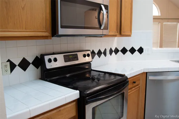a close view of a stove a microwave and a sink with wooden floor