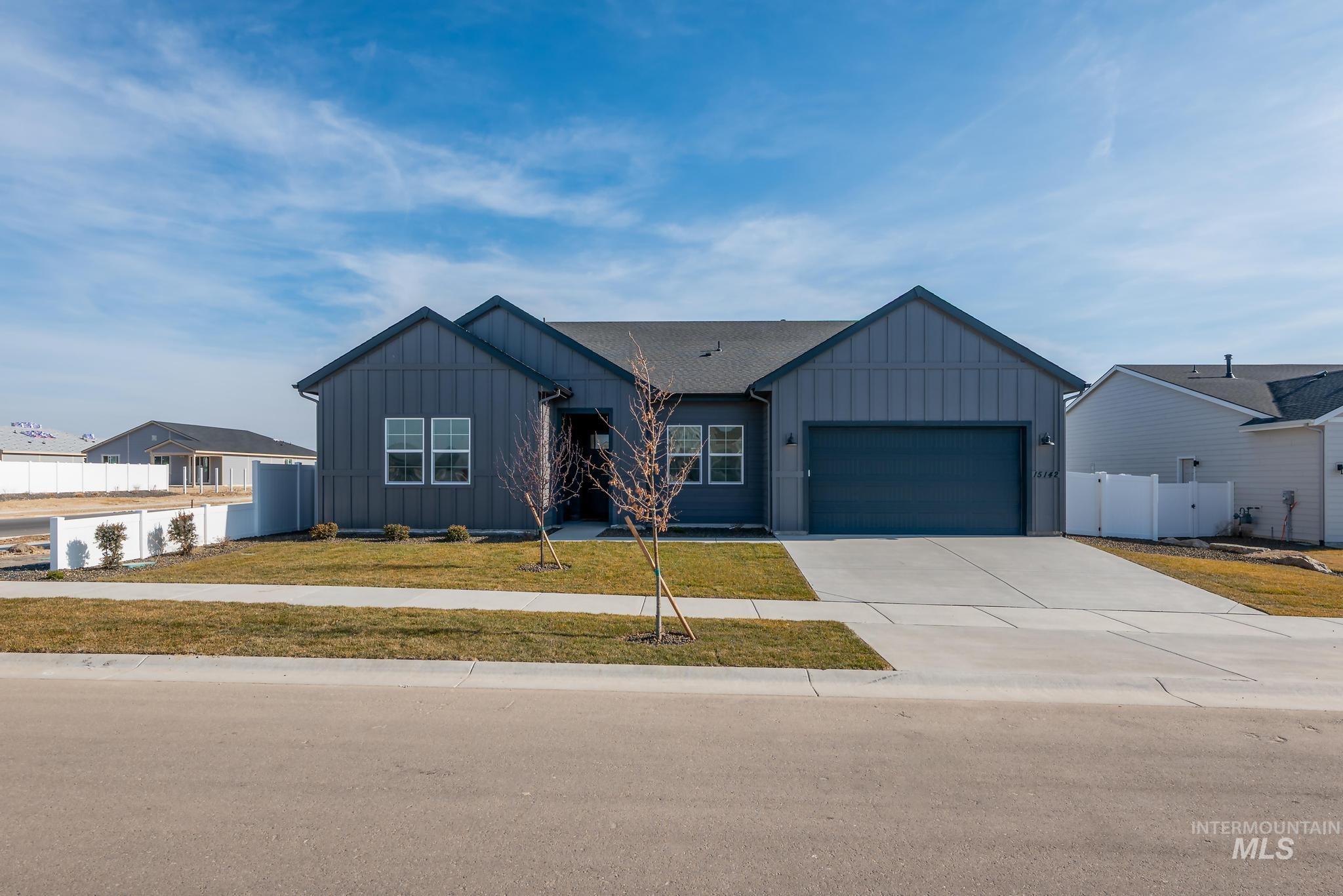 View of front of house with board and batten siding, concrete driveway, and an attached garage