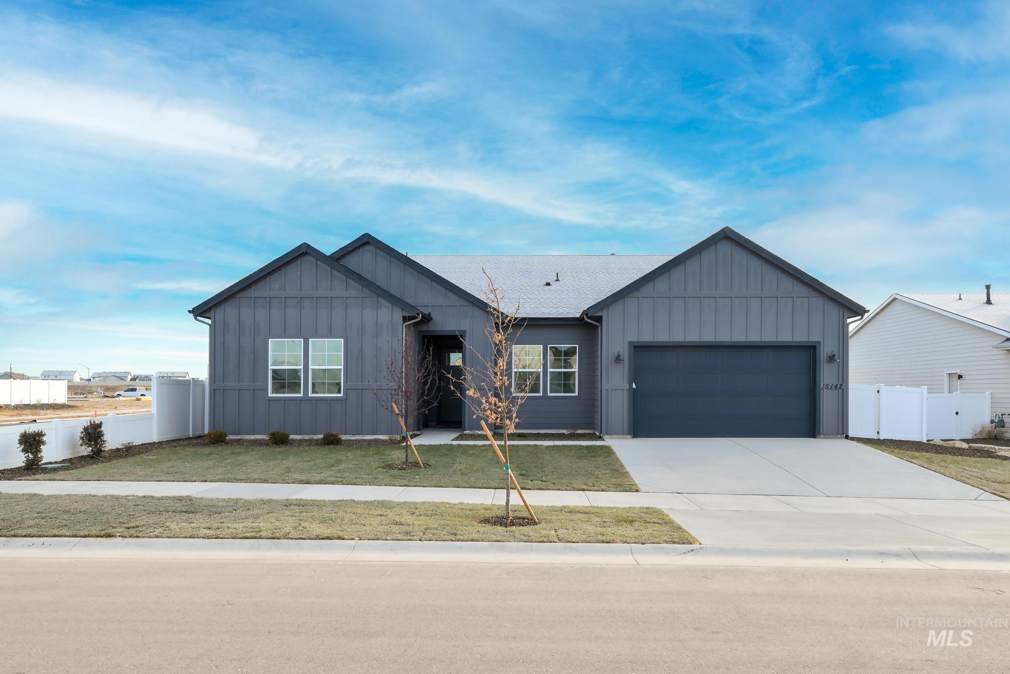 Ranch-style house featuring board and batten siding, concrete driveway, and an attached garage