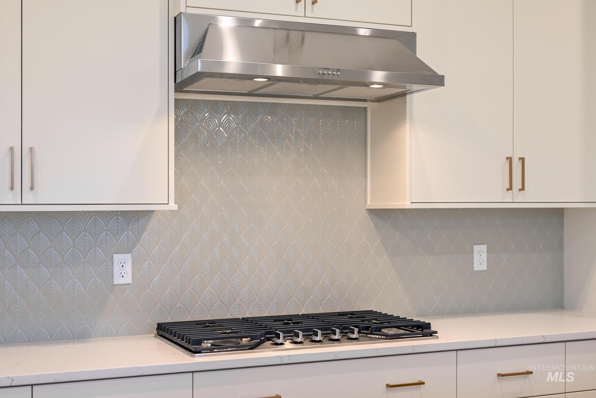 15142 Steel Cloud Avenue Caldwell, ID 83607 - Photo 10 of 34 Kitchen featuring white cabinets, backsplash, stainless steel gas stovetop, and light stone counters