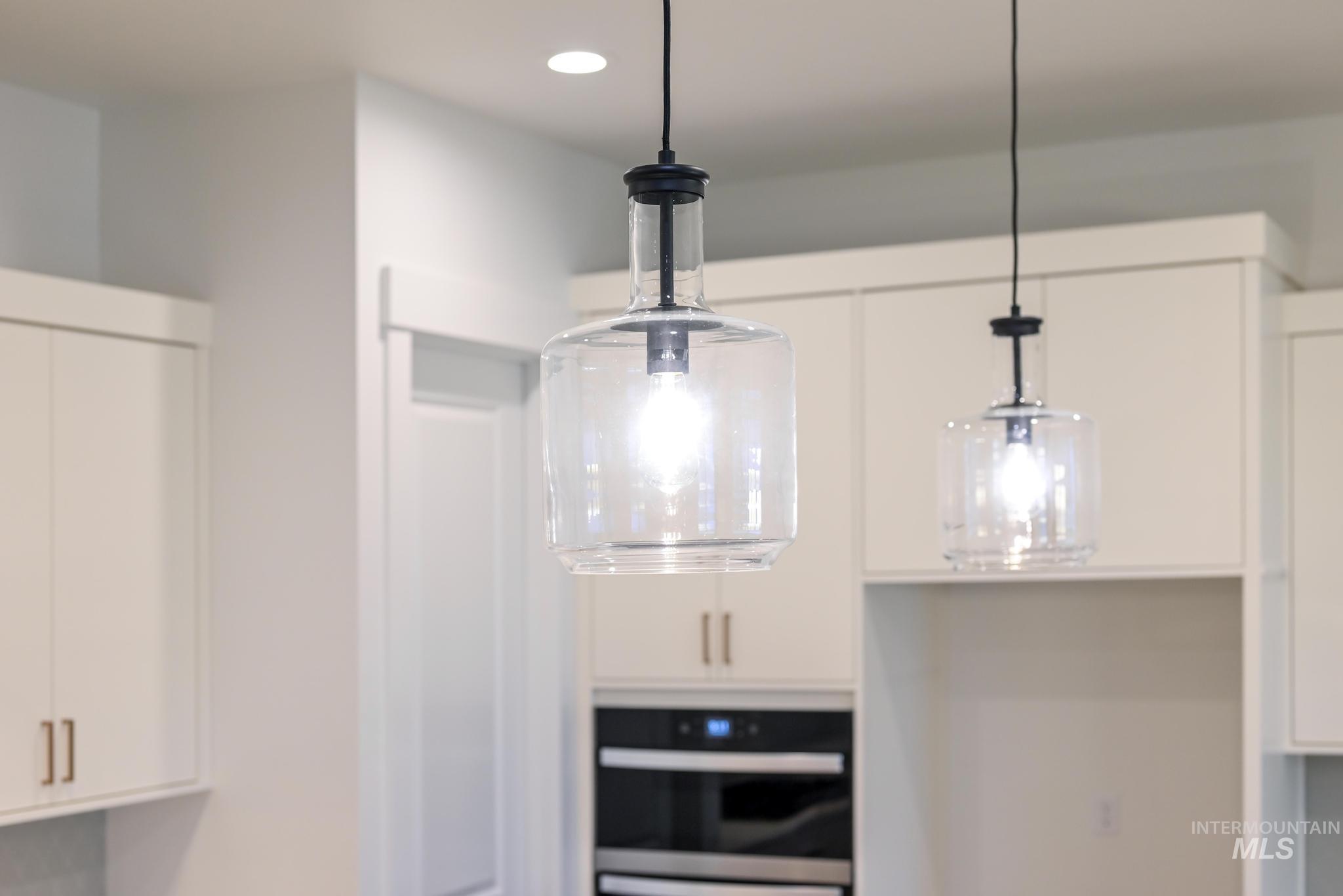 15142 Steel Cloud Avenue Caldwell, ID 83607 - Photo 16 of 44 Kitchen view of white cabinetry, hanging light fixtures, and oven