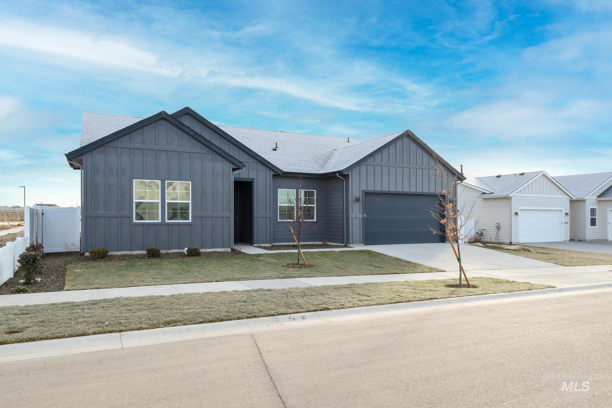 15142 Steel Cloud Avenue Caldwell, ID 83607 - Photo 2 of 34 View of front of home featuring board and batten siding, driveway, an attached garage, and a shingled roof