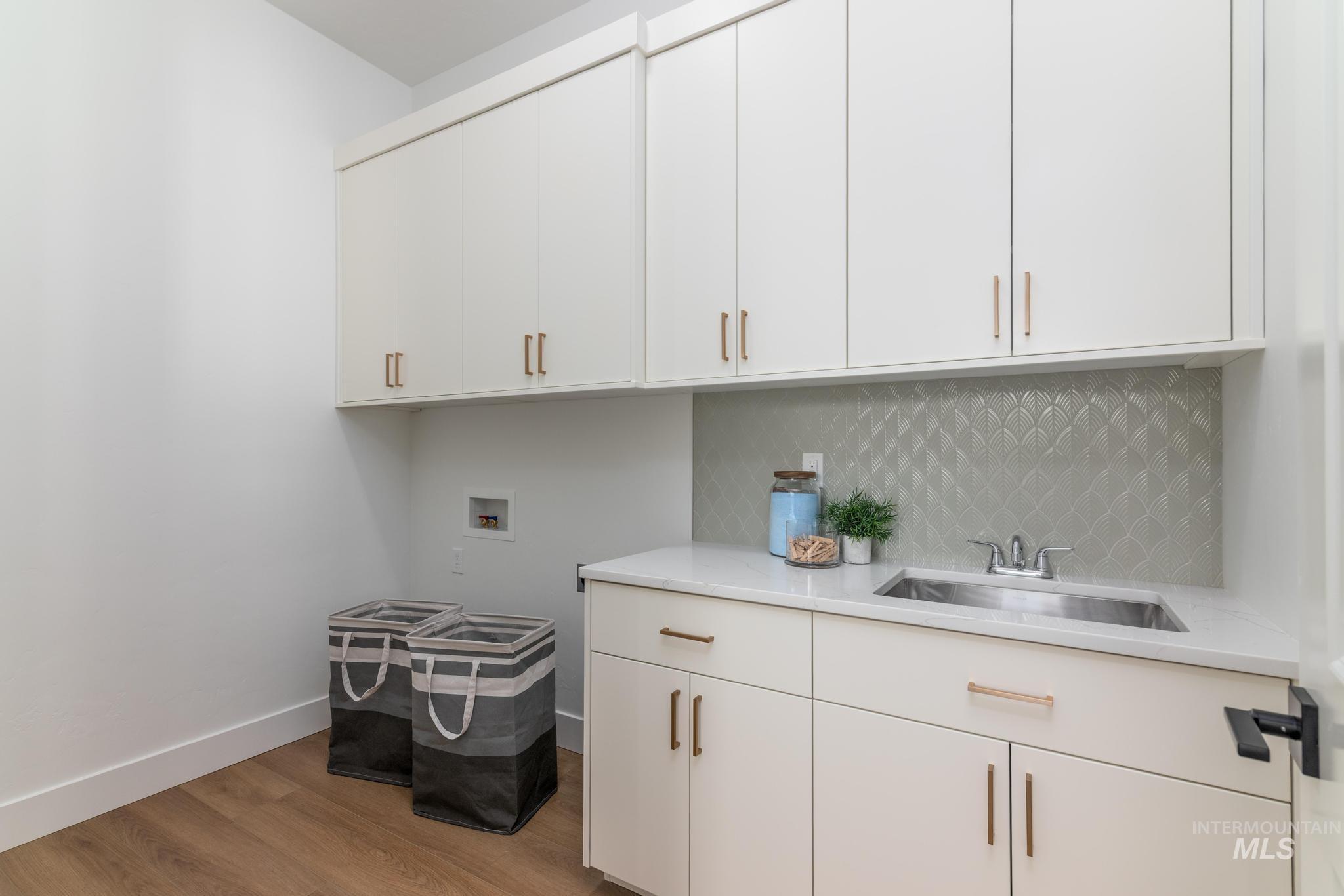 15142 Steel Cloud Avenue Caldwell, ID 83607 - Photo 30 of 44 Laundry room featuring hookup for a washing machine, cabinet space, and light wood-style flooring