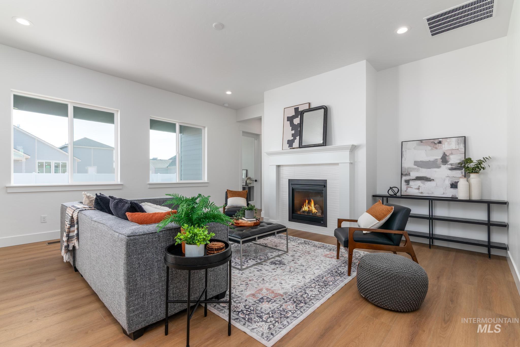 15142 Steel Cloud Avenue Caldwell, ID 83607 - Photo 4 of 44 Living area with light wood-type flooring, a glass covered fireplace, and recessed lighting