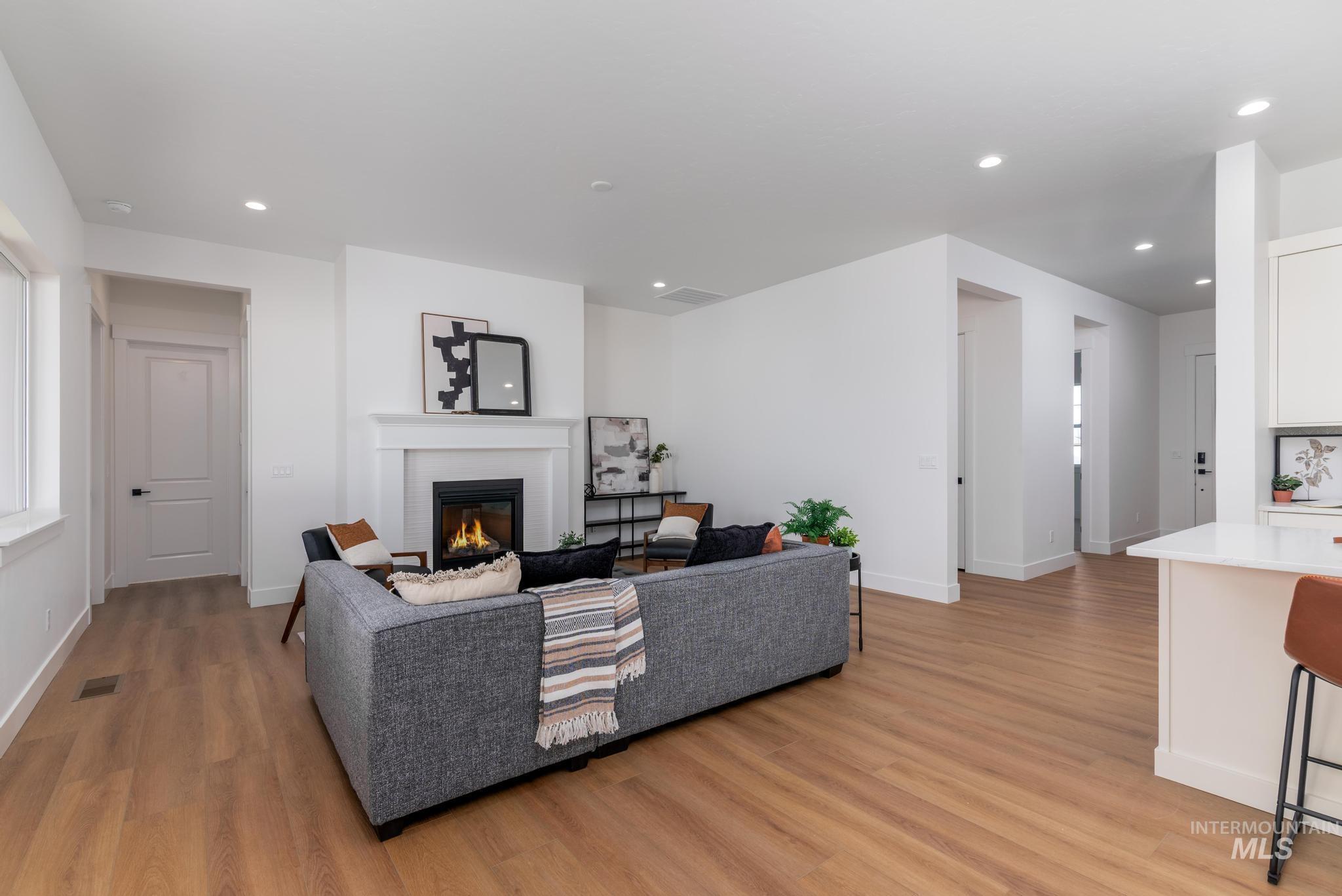 15142 Steel Cloud Avenue Caldwell, ID 83607 - Photo 5 of 44 Living area featuring light wood finished floors, a glass covered fireplace, and recessed lighting