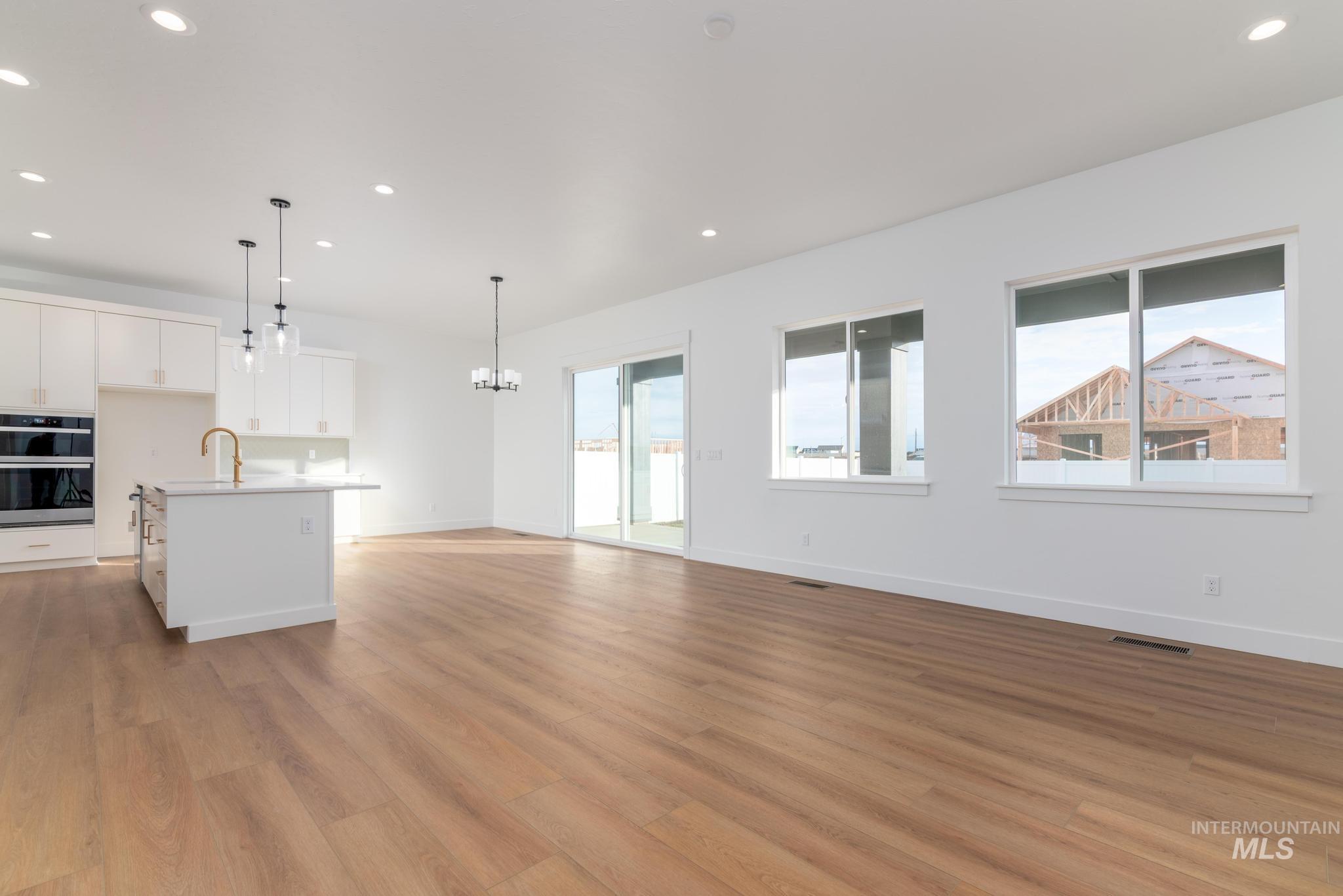 15142 Steel Cloud Avenue Caldwell, ID 83607 - Photo 7 of 34 Unfurnished living room with light wood-type flooring and hanging lights