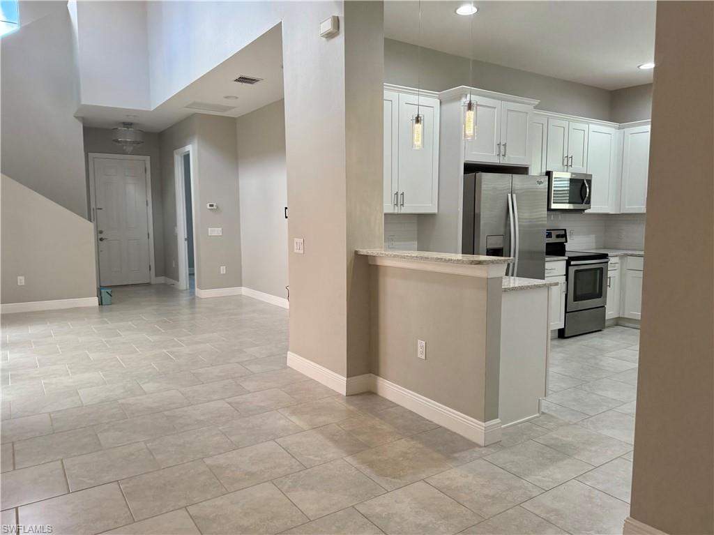 a view of a kitchen with refrigerator and furniture