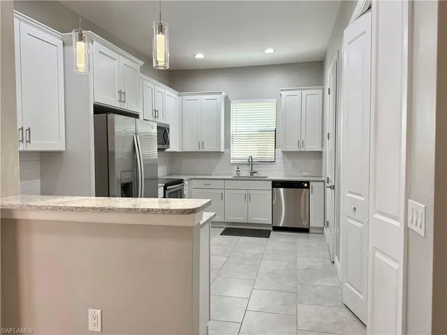 a kitchen with stainless steel appliances a refrigerator sink and cabinets