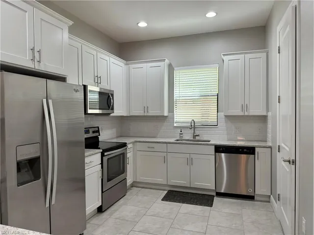 a kitchen with stainless steel appliances granite countertop a refrigerator and a sink