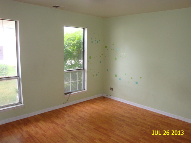 250 Rodenburg Road Roselle, IL 60172 - Photo 3 of 13 an empty room with wooden floor and windows