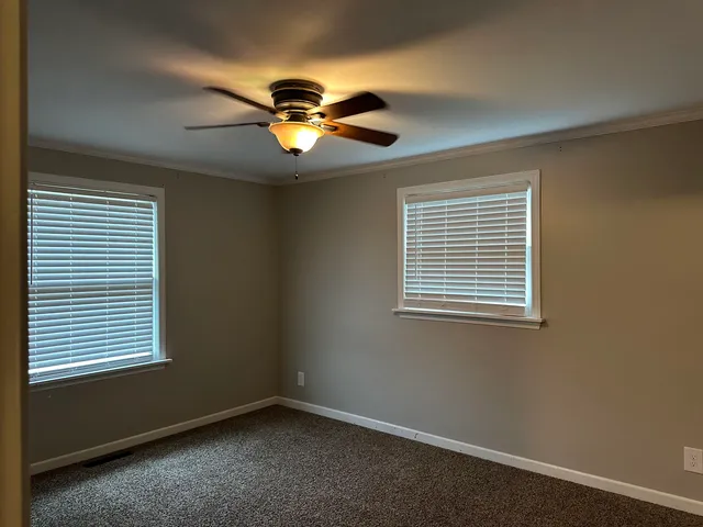 an empty room with a window and a ceiling fan