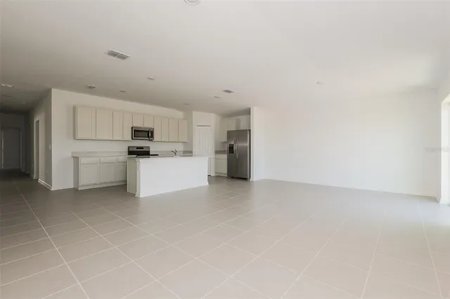 a view of a refrigerator in kitchen and white cabinets