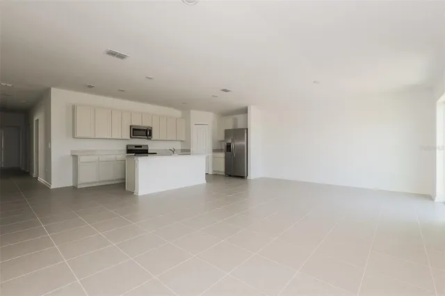 a view of a refrigerator in kitchen and white cabinets