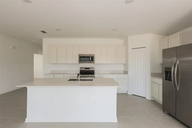 a kitchen with stainless steel appliances a refrigerator sink and stove
