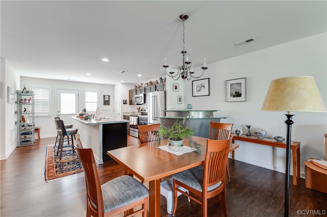 1314 Stone Rdg Pk Loop Henrico, VA 23228 - Photo 6 of 20 Hardwood floored dining area featuring a notable chandelier, a breakfast bar area, natural light, and microwave