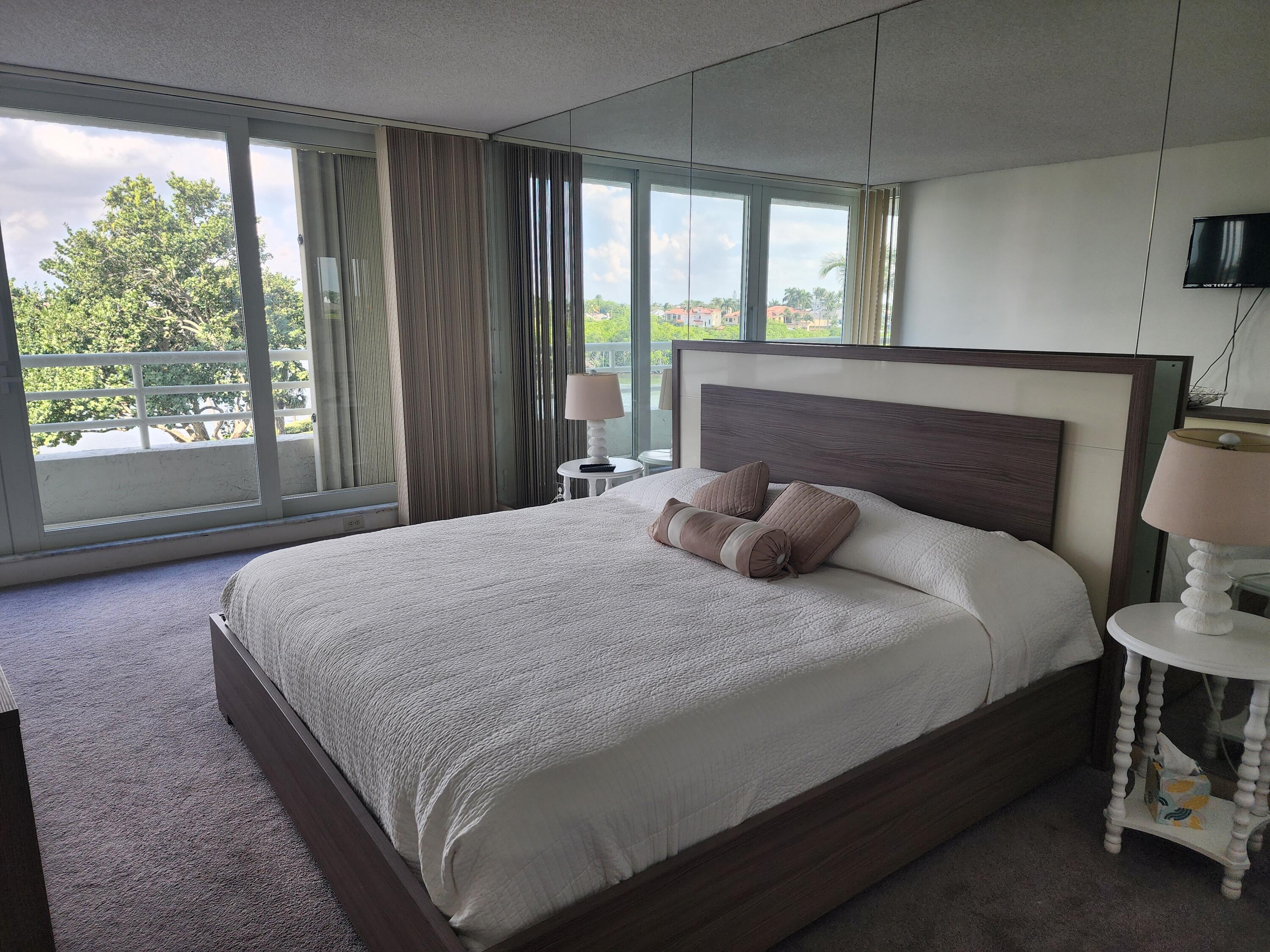 4201 North Ocean Boulevard, Unit 307 Boca Raton, FL 33431 - Photo 29 of 38 a large bed sitting in a bedroom next to a window