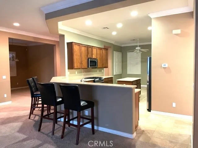 a kitchen with stainless steel appliances kitchen island granite countertop a table and chairs