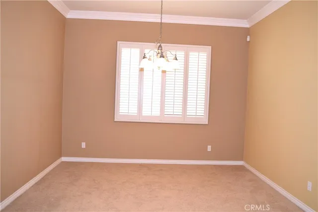 an empty room with windows and chandelier