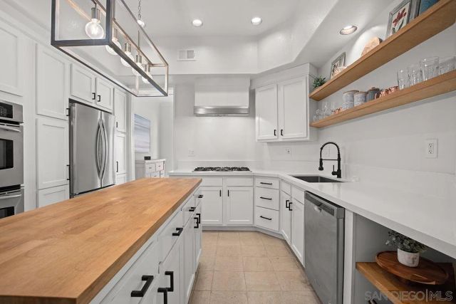 a kitchen with stainless steel appliances kitchen island granite countertop a refrigerator and microwave