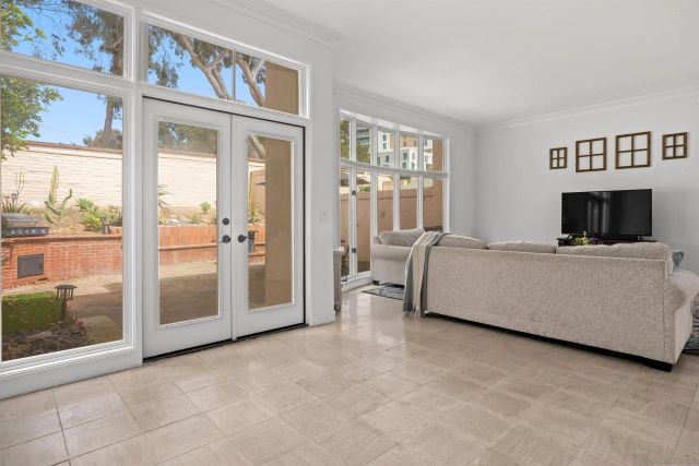 a living room with furniture a large window and a flat screen tv