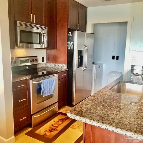 a kitchen with stainless steel appliances granite countertop a stove microwave and refrigerator