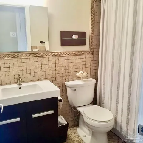 a bathroom with a toilet a sink and a mirror