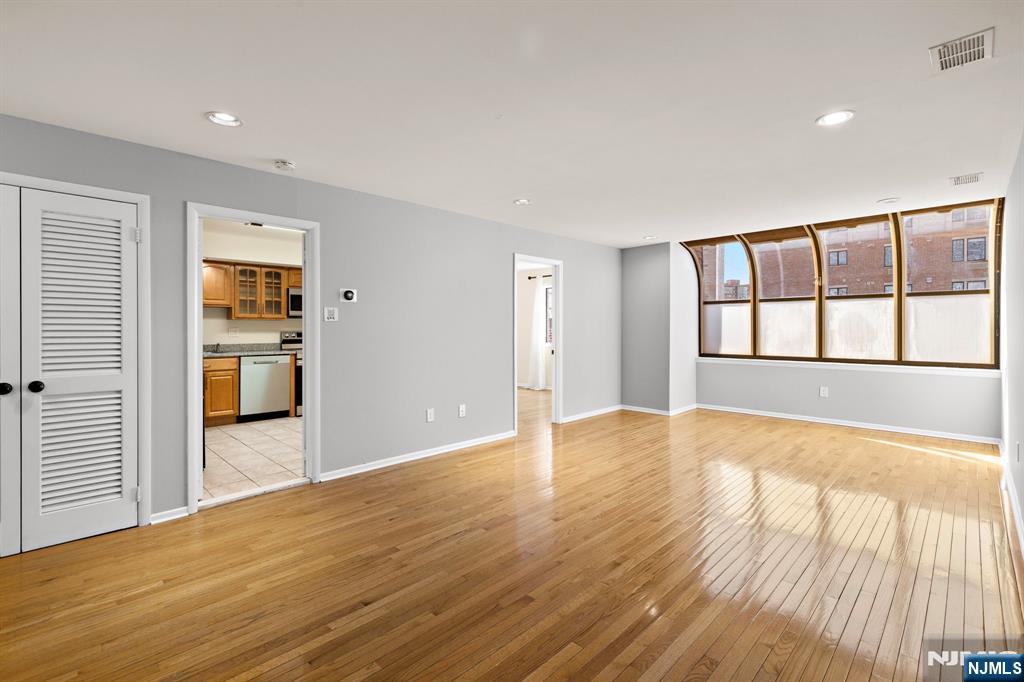 319 Gorge Road, Unit 6 Cliffside Park, NJ 07010 - Photo 4 of 24 a view of an empty room with wooden floor and a window