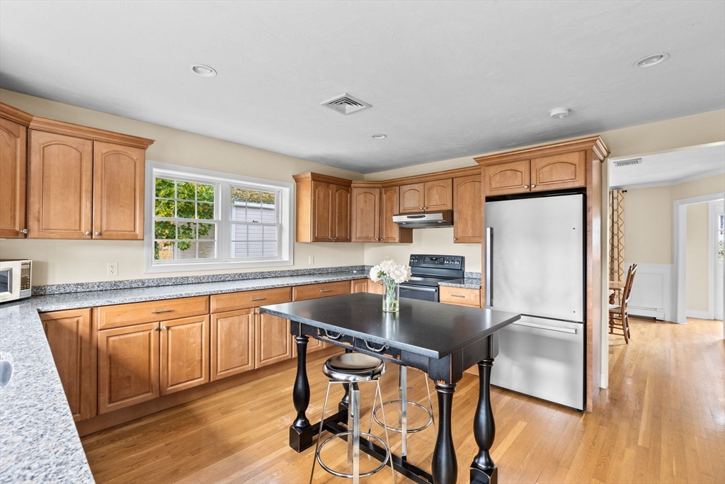 8 Hayes Road Hingham, MA 02043 - Photo 3 of 25 a kitchen with stainless steel appliances granite countertop a refrigerator a microwave a stove and white cabinets with wooden floor
