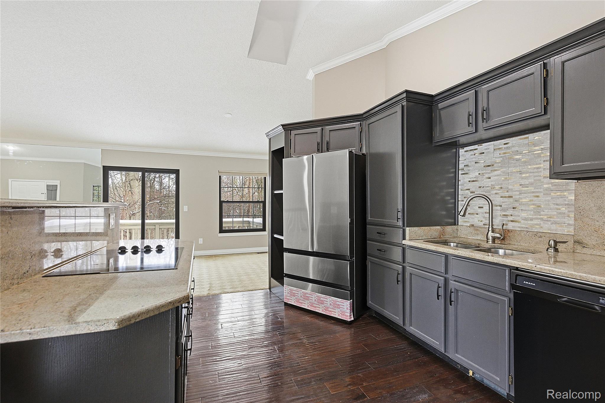 7154 Westchester Road West Bloomfield, MI 48322 - Photo 3 of 38 Kitchen with ornamental molding, black appliances, light stone countertops, tasteful backsplash, and gray cabinets