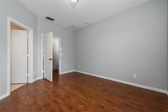 a view of an empty room with wooden floor