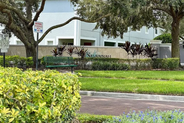 a front view of a house with a garden and a tree