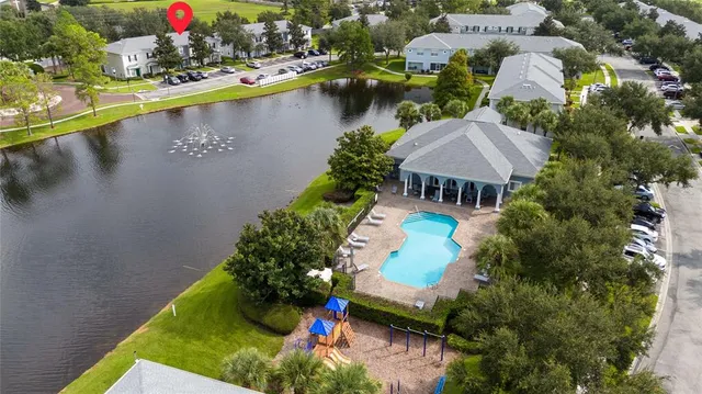 an aerial view of residential houses with outdoor space and lake view