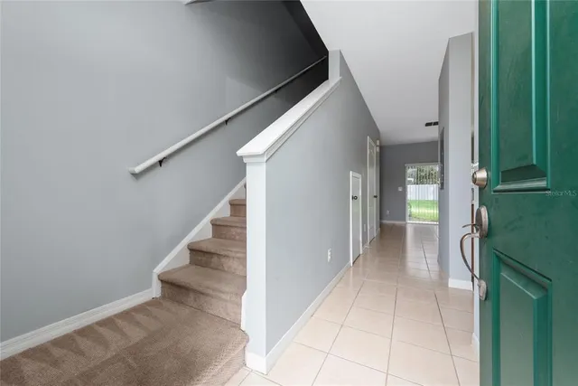 a view of a hallway with entryway and stairs