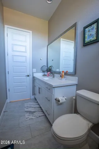 a bathroom with a toilet sink vanity and mirror