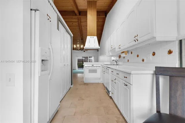 a kitchen with white cabinets and white appliances