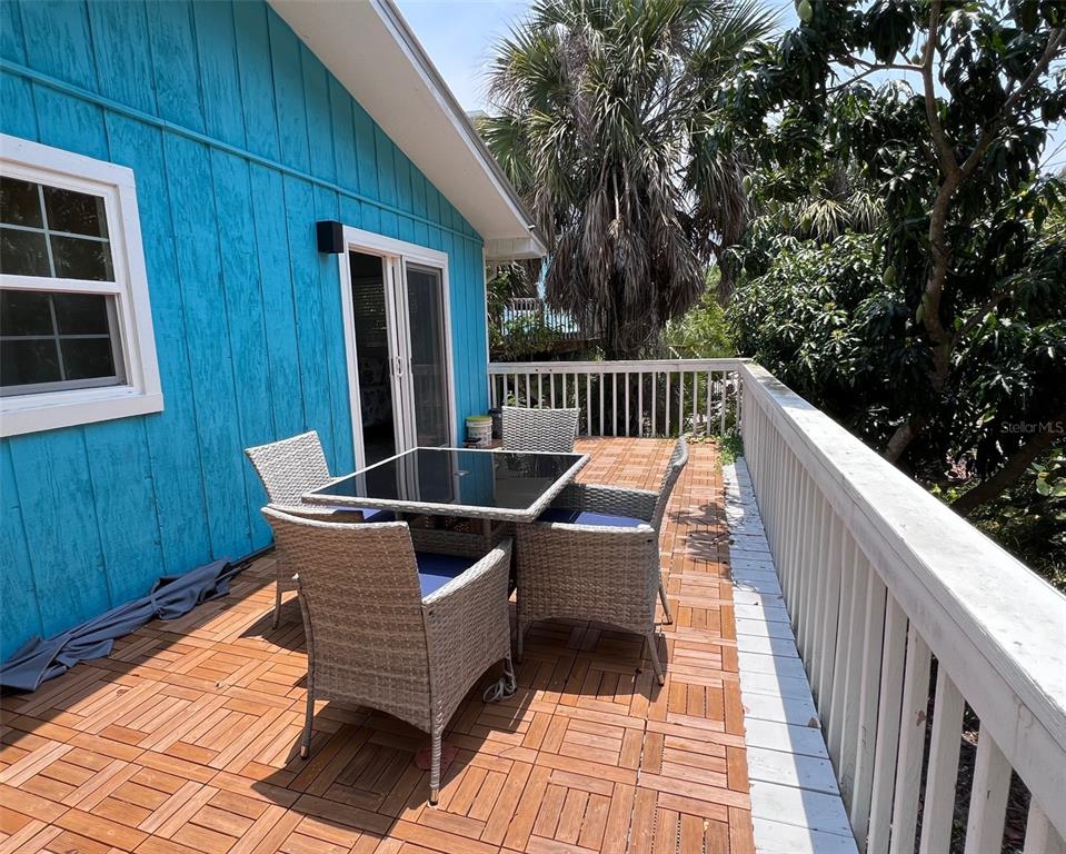 8142 Little Gasparilla Placida, FL 33946 - Photo 24 of 38 a view of balcony with wooden floor and outdoor seating